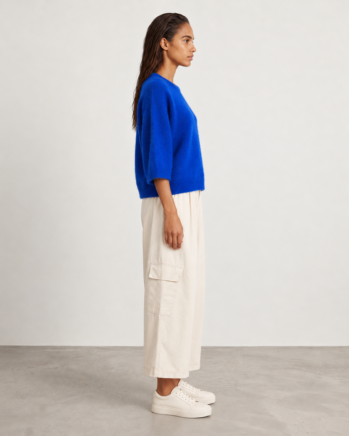 Pull Bestie Bleu elettrico porté de profil avec le pantalon Auguste cargo écru antique